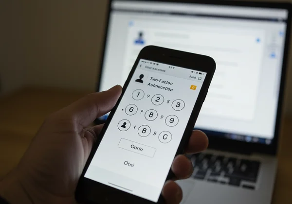 Phone displaying a 2FA code protecting a login screen.